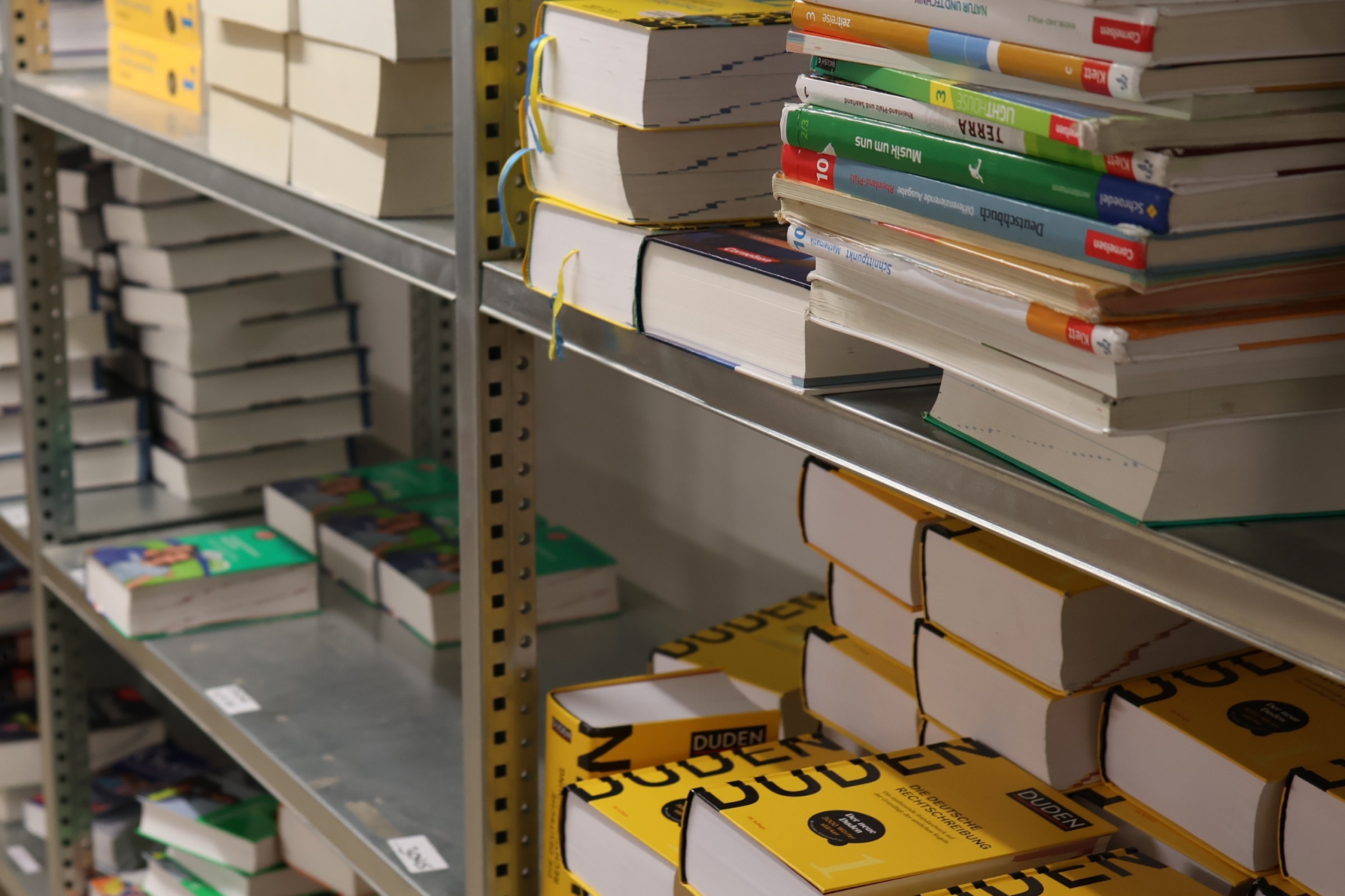 In einem Regal lagern verschiedene Schulbücher.