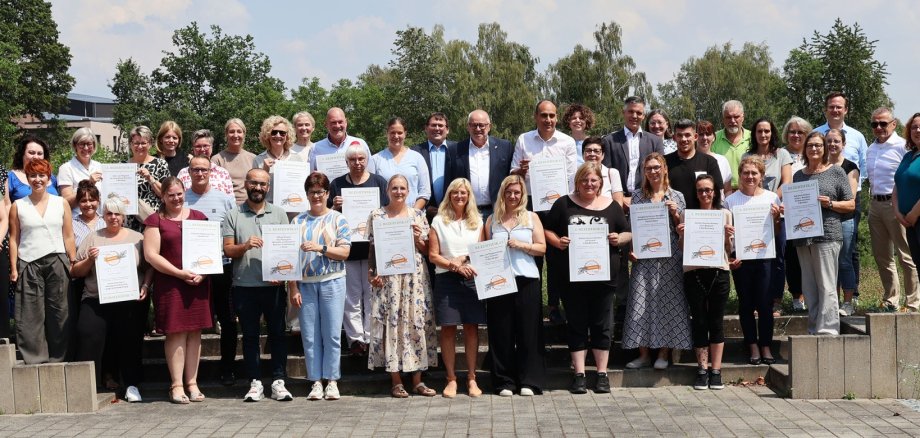 Viele Menschen halten ihr Zertifikat hoch.