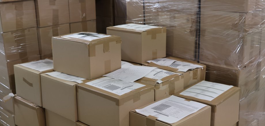 Kartons stehen gestapelt bereit für die Auslieferung.