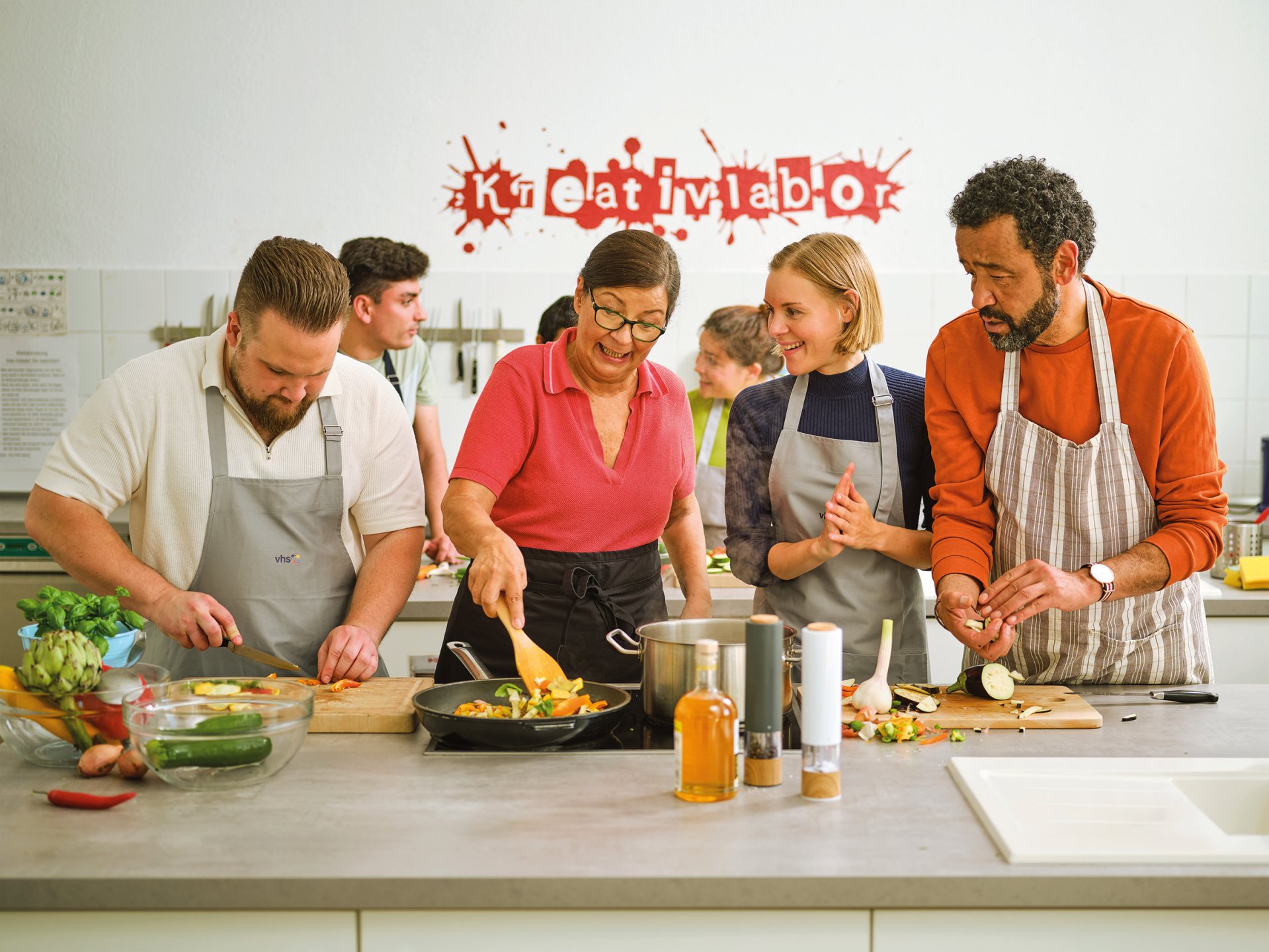 Eine Gruppe von Menschen kocht zusammmen.