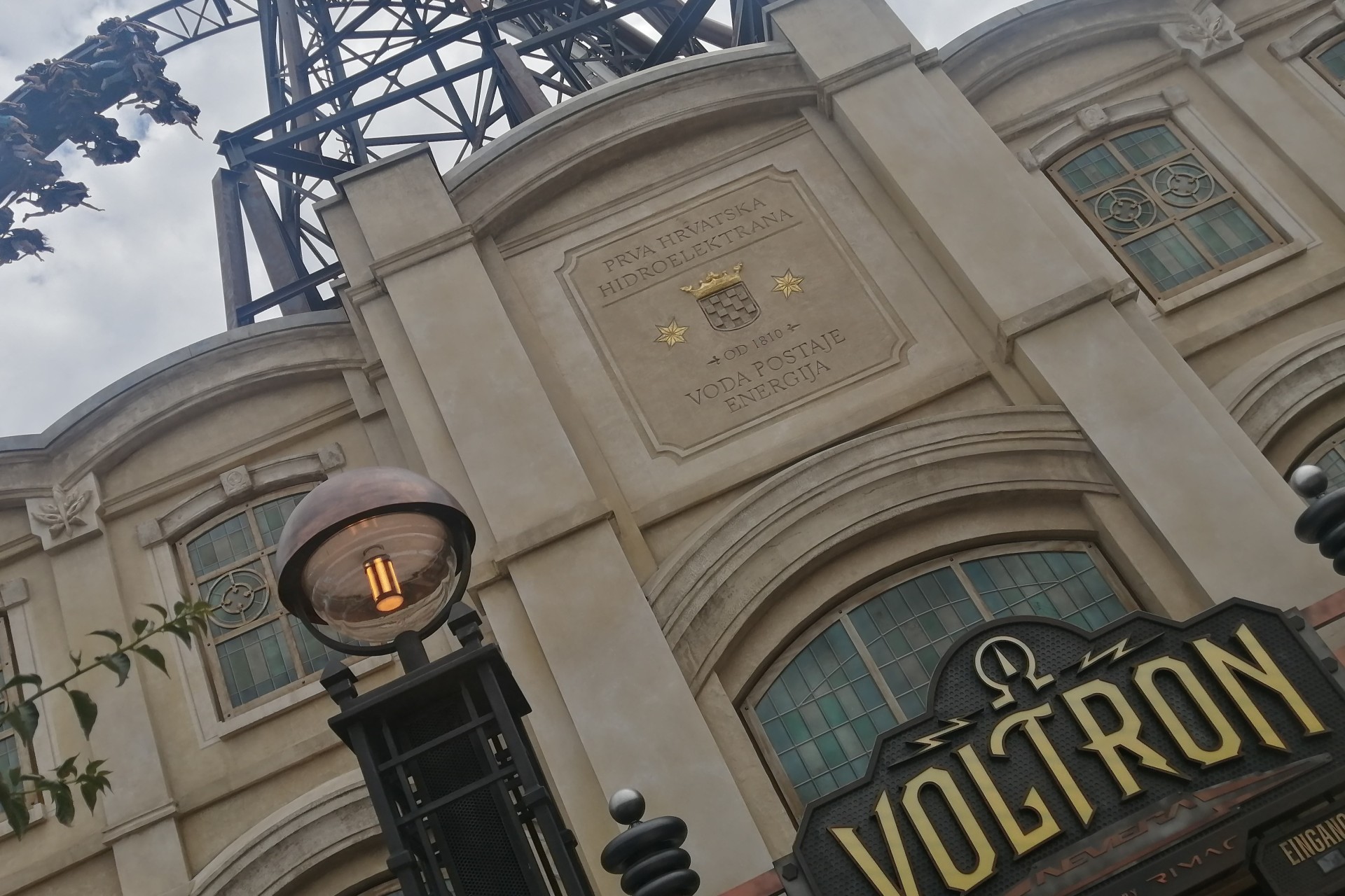Über einem Gebäude mit der Aufschrift "Voltron" fährt eine Achterbahn.