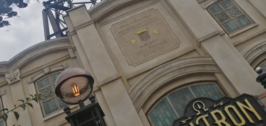Über einem Gebäude mit der Aufschrift "Voltron" fährt eine Achterbahn.