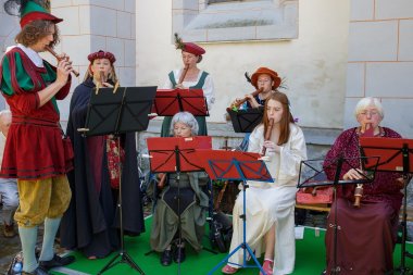 Frauen und Männer im mittelalterlichen Kostüm spielen Blockflöten