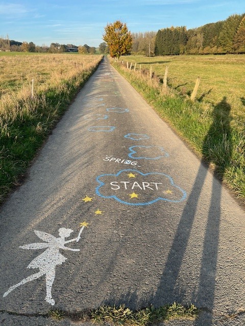 Auf einer Straße sind Feen und Laufanweisungen gemalt.