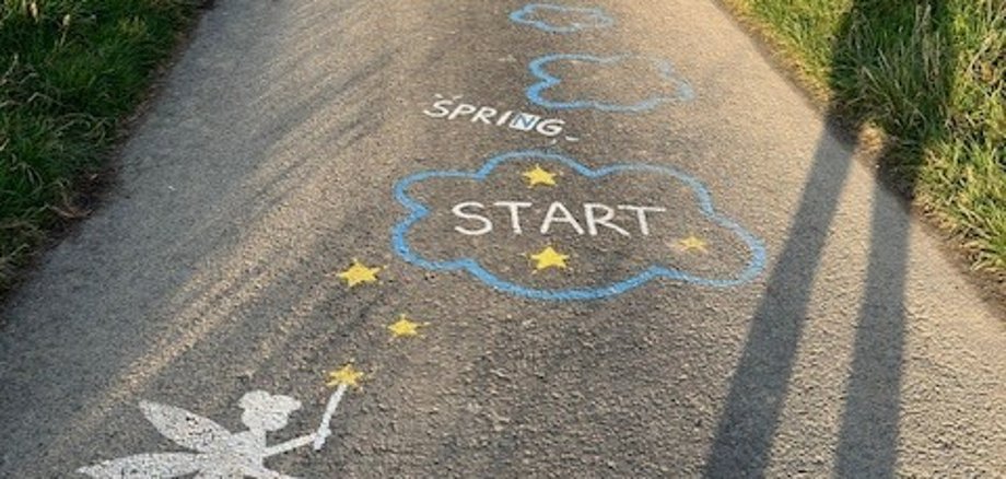 Auf einer Straße sind Feen und Laufanweisungen gemalt.
