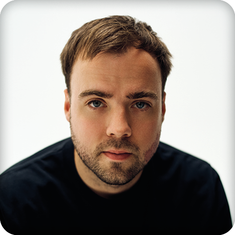 Ein junger Mann schaut in die Kamera.