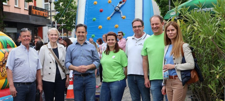 Frauen und Männer stehen vor einer großen aufblasbaren Kletterwand.