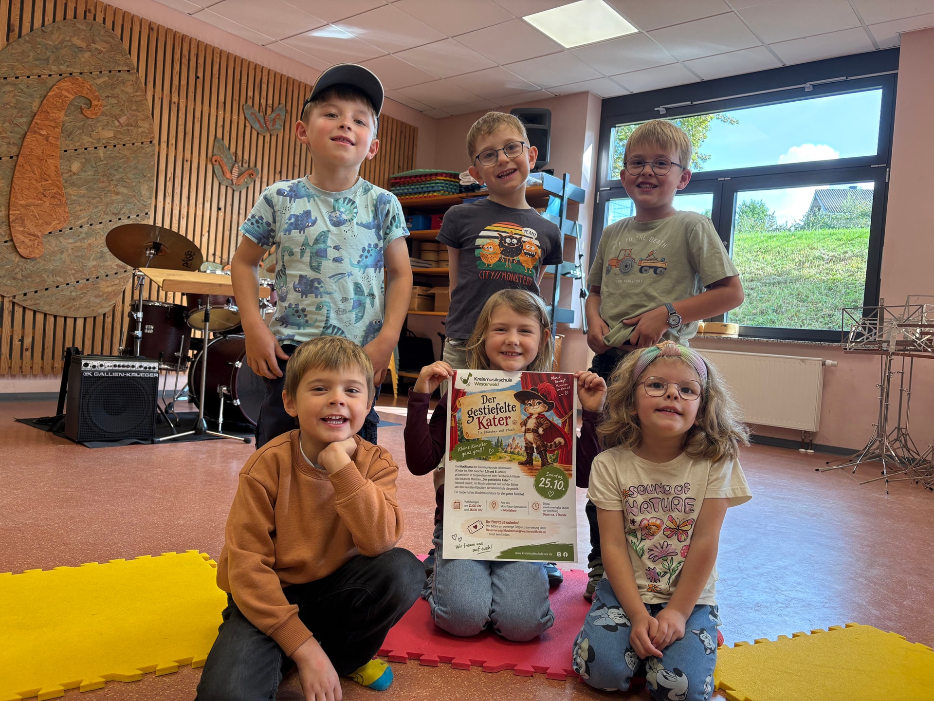 Kinder halten das Plakat zur Veranstaltung hoch.
