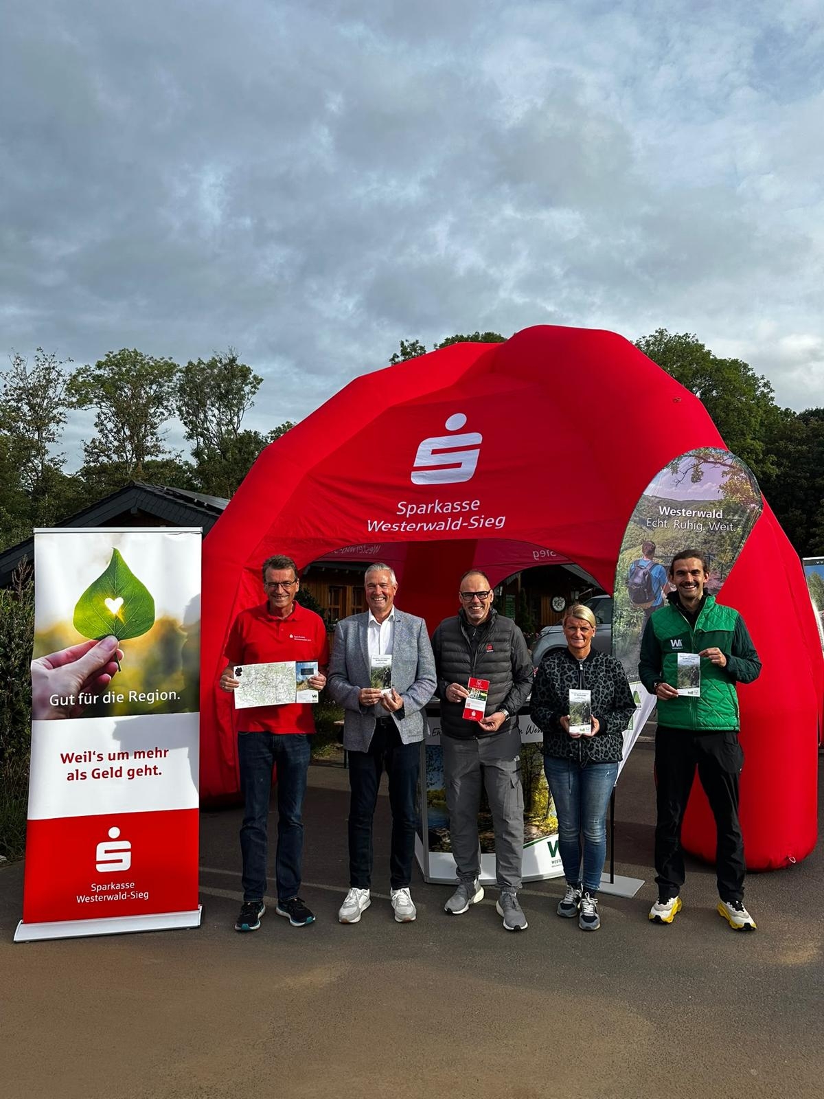 Mehrere Personen stehen vor einem roten Zelt der Sparkasse Westerwald-Sieg.