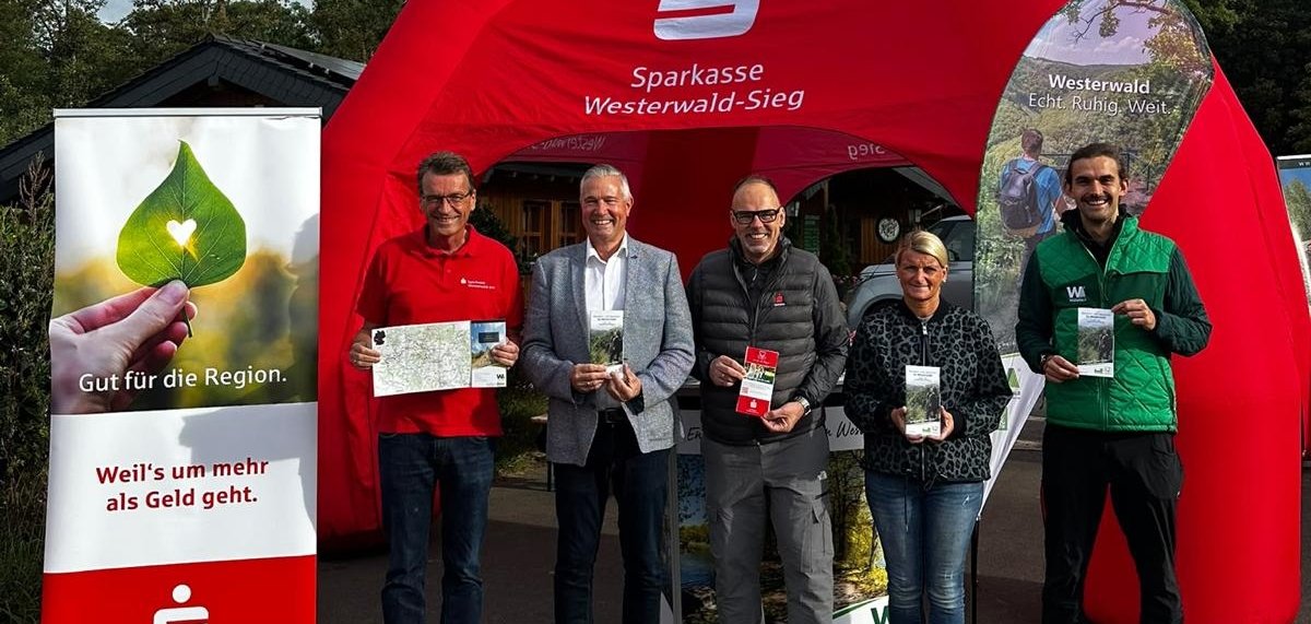 Mehrere Personen stehen vor einem roten Zelt der Sparkasse Westerwald-Sieg.