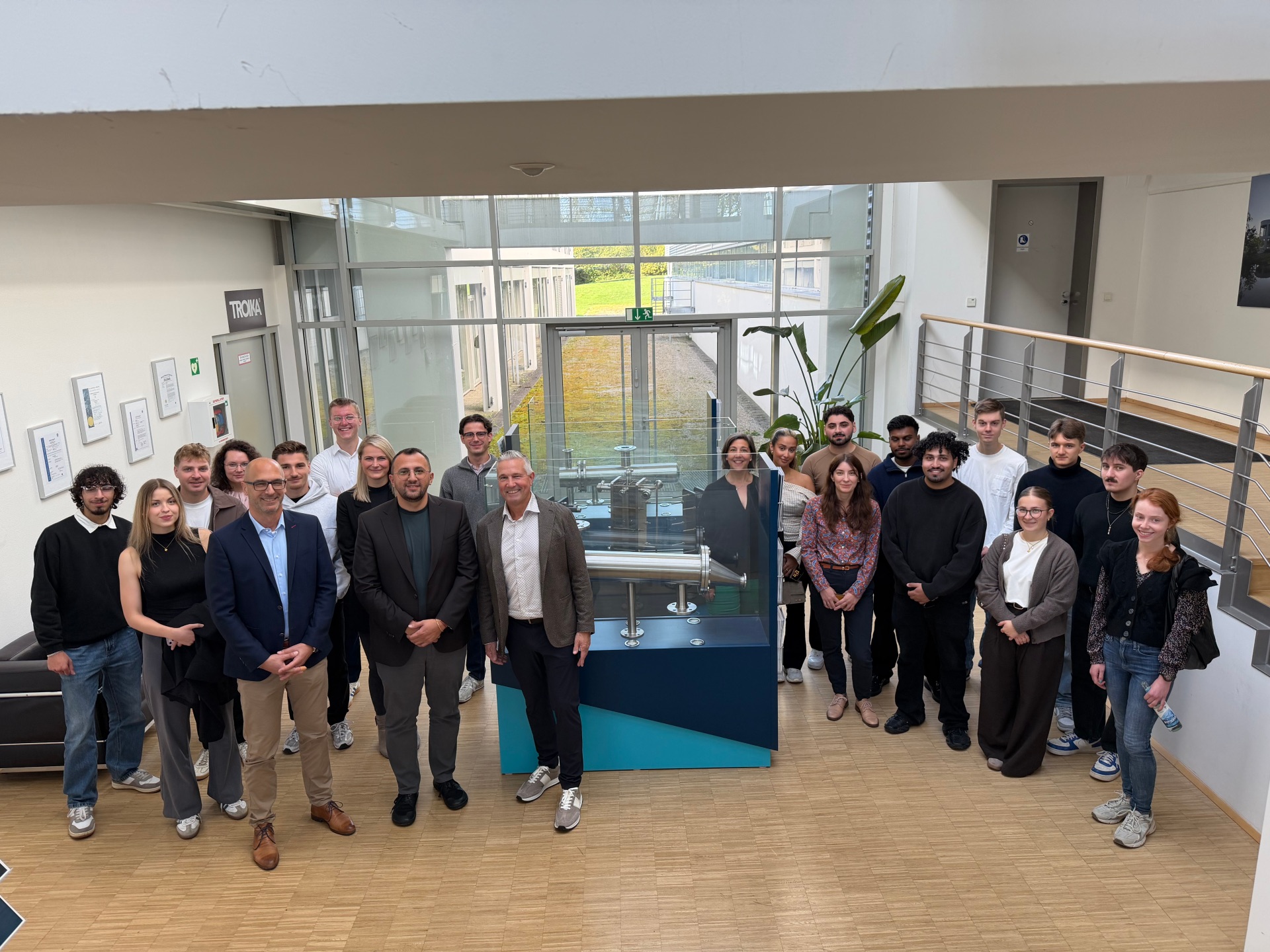 Gruppe Menschen vor bei einem Industrieexponat