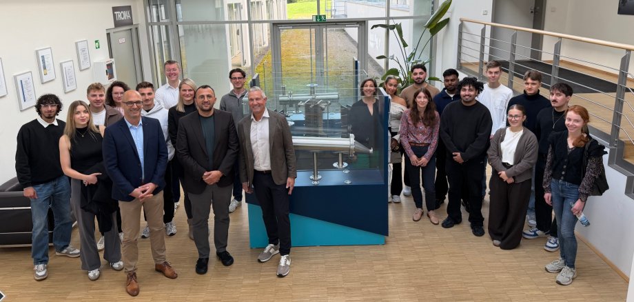 Gruppe Menschen vor bei einem Industrieexponat
