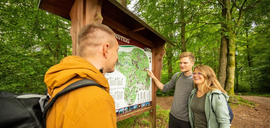 Wanderer stehen vor einem Schild des Druidensteigs.
