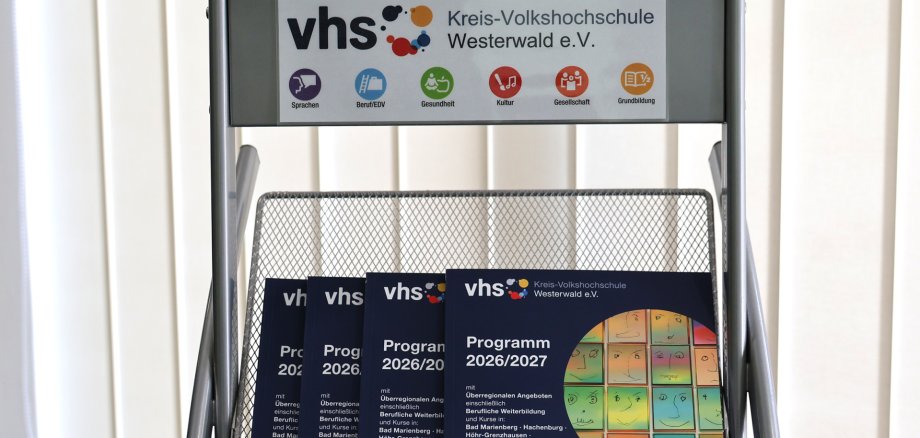 In einem Ständer liegen Kurshefte der Kreis-vhs.