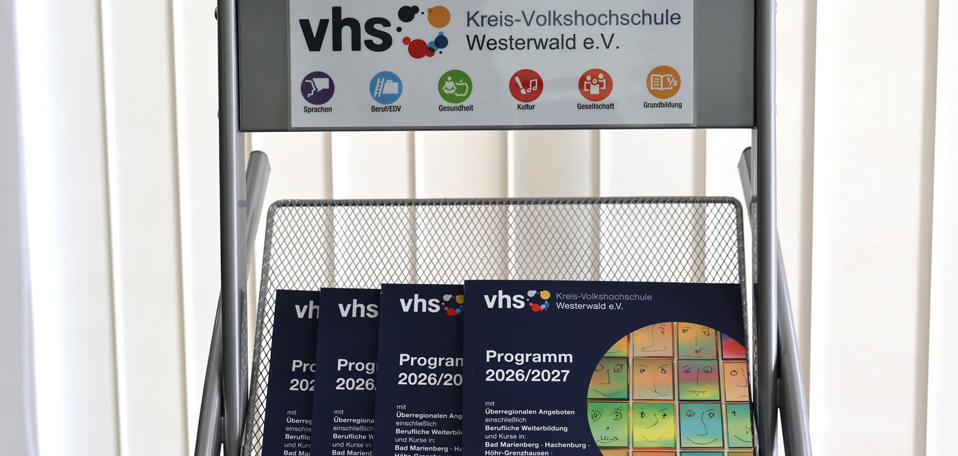 In einem Ständer liegen Kurshefte der Kreis-vhs.