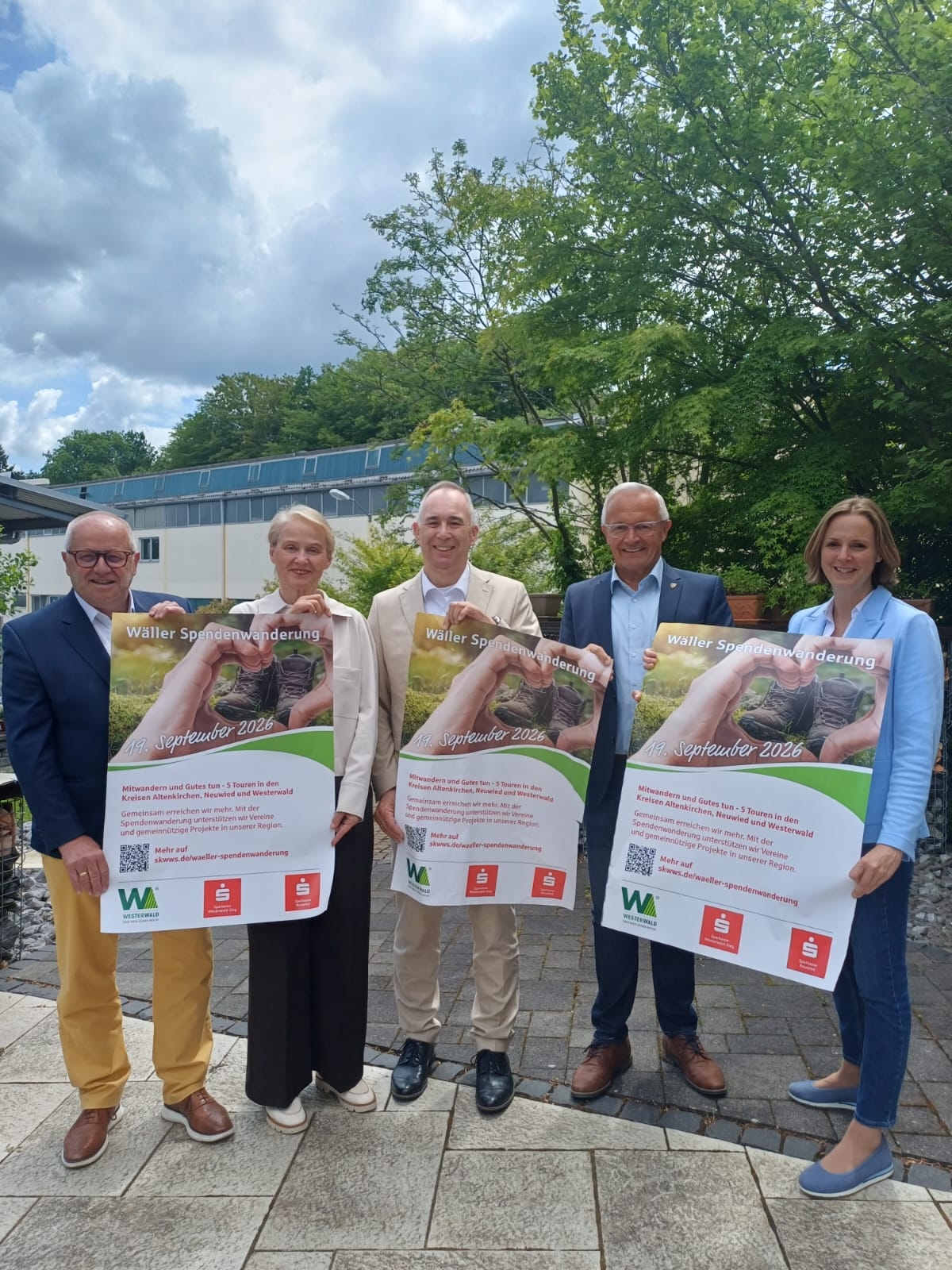 Männer und Frauen halten Plakate in der Hand.