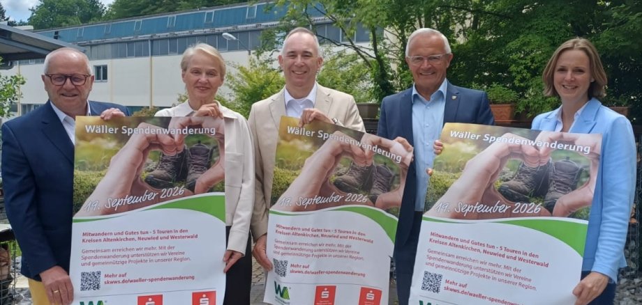 Männer und Frauen halten Plakate in der Hand.