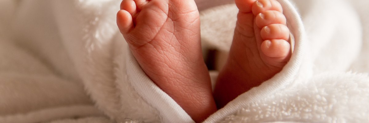 Eingewickelte nackte Babyfüße.