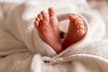 Eingewickelte nackte Babyfüße.