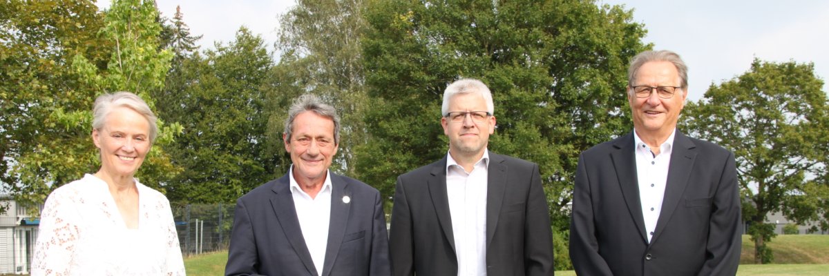 Auf einer Wiese stehen nebeneinander von links nach rechts Erste Kreisbeigeordnete Gabriele Wieland, Landrat Achim Schwickert, Kreisbeigeordneter Andreas Strüder und Kreisbeigeordneter Klaus Ortseifen.