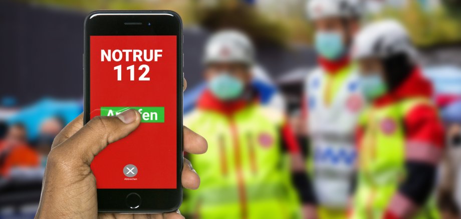 Notruf 112 anrufen Eine Hand wählt über die 112 den Notruf.