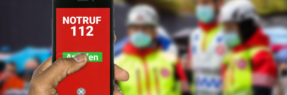Notruf 112 anrufen Eine Hand wählt über die 112 den Notruf.