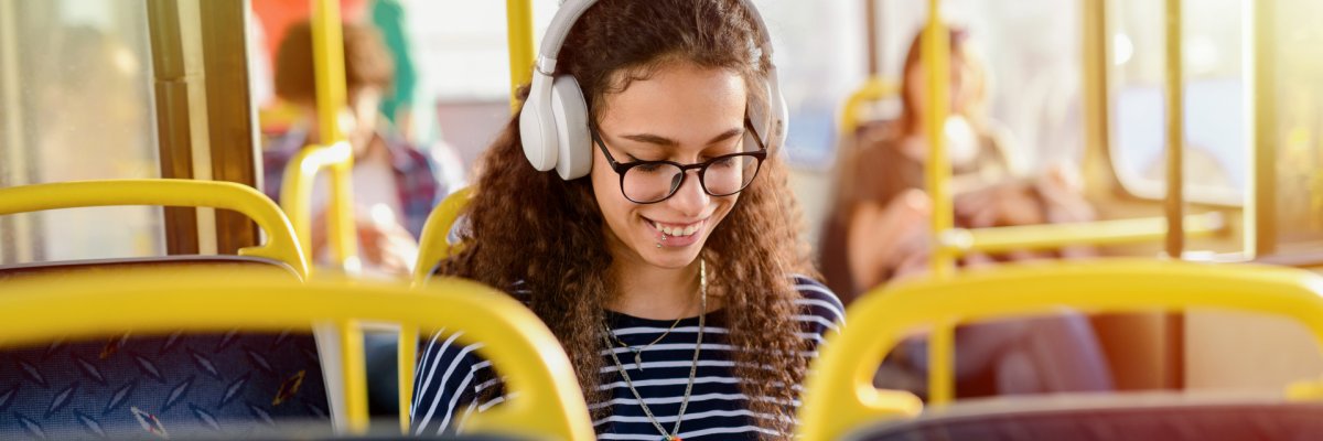 Eine junge Frau sitzt in einem Bus und liest.