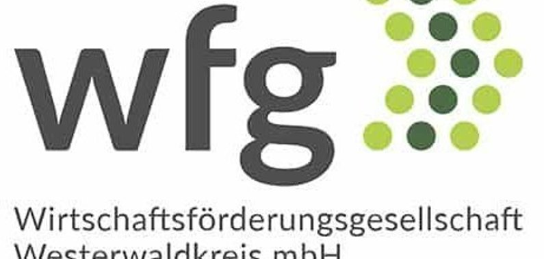 Im Logo ist der Schriftzug wfg - Wirtschaftsförderungsgesellschaft Westerwaldkreis mbH mit einem Pfeil zu sehen, der aus grünen Punkten besteht.