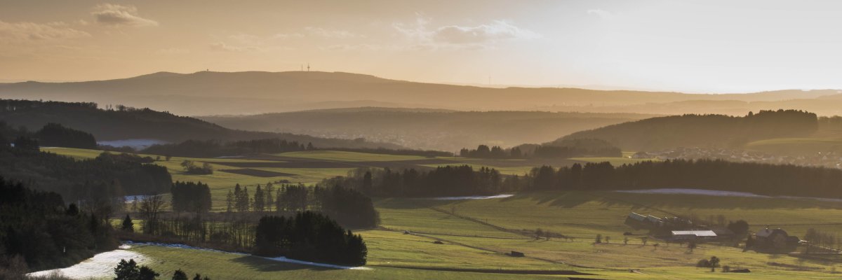 eine dunkle stellenweise schneebedeckte winterliche Landschaft.