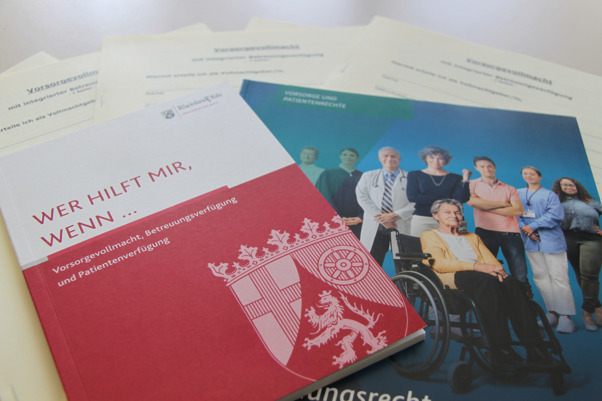 Verschiedene Broschüre und Formulare liegen auf einem Tisch.