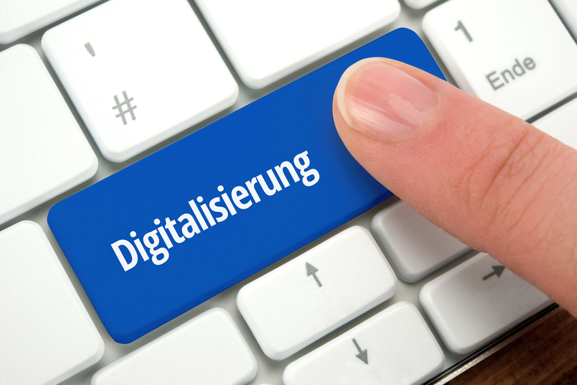 Auf einer PC-Tastatur zeigt ein Finger auf die Sondertaste "Digitalisierung".