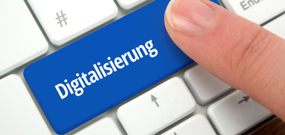 Digitalisierung Auf einer PC-Tastatur zeigt ein Finger auf die Sondertaste "Digitalisierung".