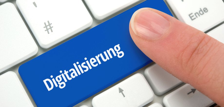 Digitalisierung Auf einer PC-Tastatur zeigt ein Finger auf die Sondertaste "Digitalisierung".