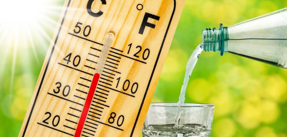 Ein Thermometer zeigt über 40 Grad Celsius und aus einer Flasche wird Wasser in ein Gals geschenkt.