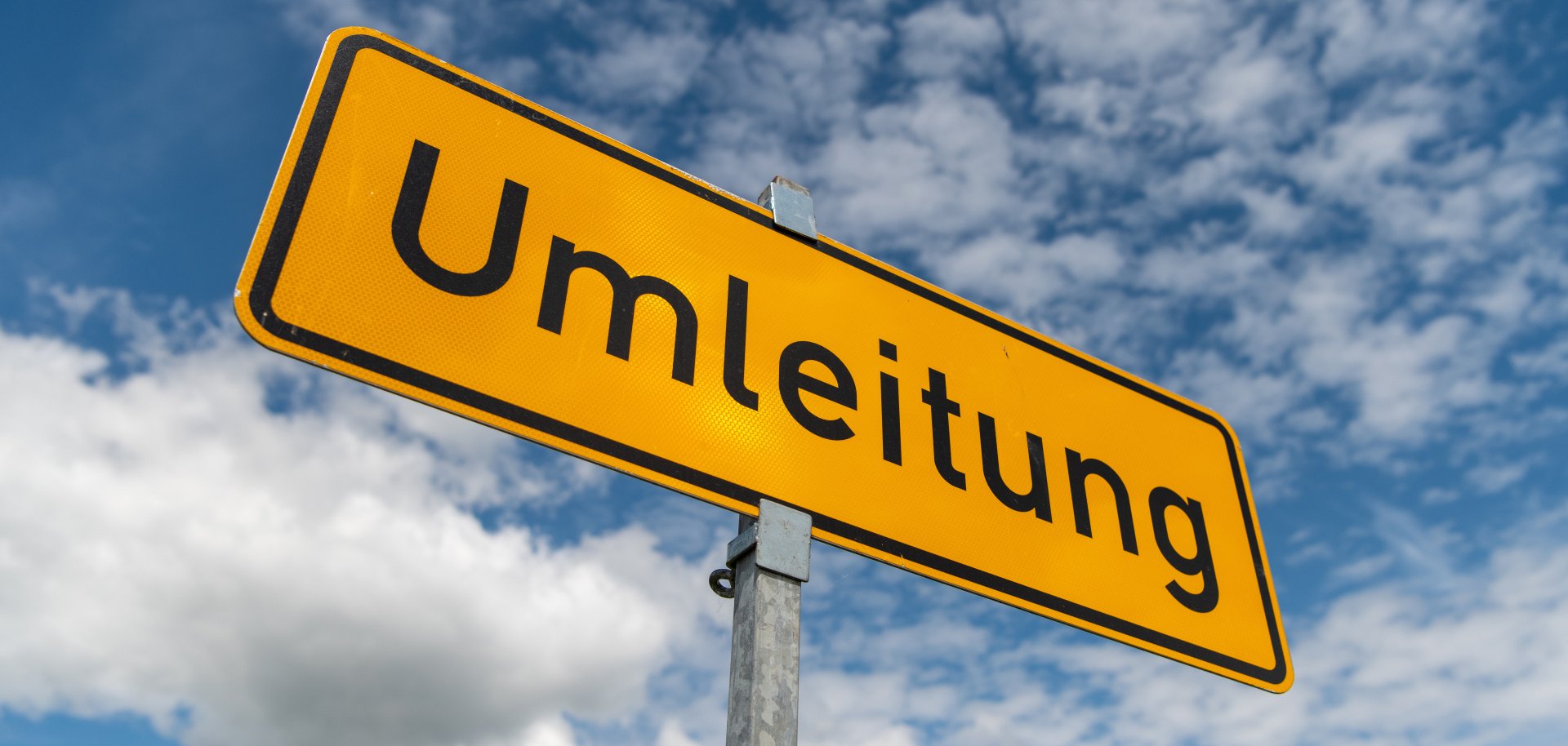 Ein Umleitungsschild vor blauem Himmel.