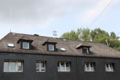 Auf dem Dach eines Hauses ist eine Sirene angebracht.