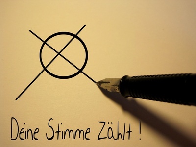 Ein Kuli macht ein Kreuz auf einem Wahlzettel.
