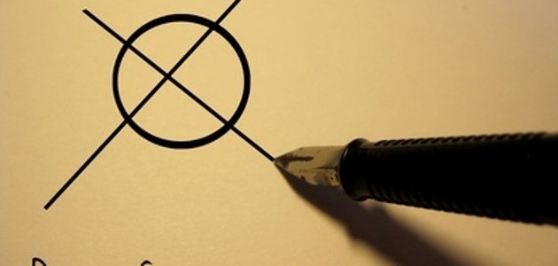Ein Kuli macht ein Kreuz auf einem Wahlzettel.
