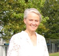 Die hauptamtliche Erste Kreisbeigeordnete Gabriele Wieland steht auf einer Wiese und blickt in die Kamera.