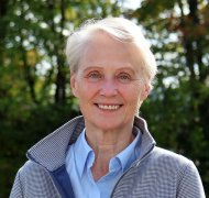 Die hauptamtliche Erste Kreisbeigeordnete Gabriele Wieland steht auf einer Wiese und blickt in die Kamera.