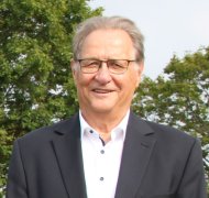 Kreisbeigeordneter Klaus Ortseifen steht auf einer Wiese und blickt in die Kamera.