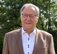 Kreisbeigeordneter Klaus Ortseifen steht auf einer Wiese und blickt in die Kamera.