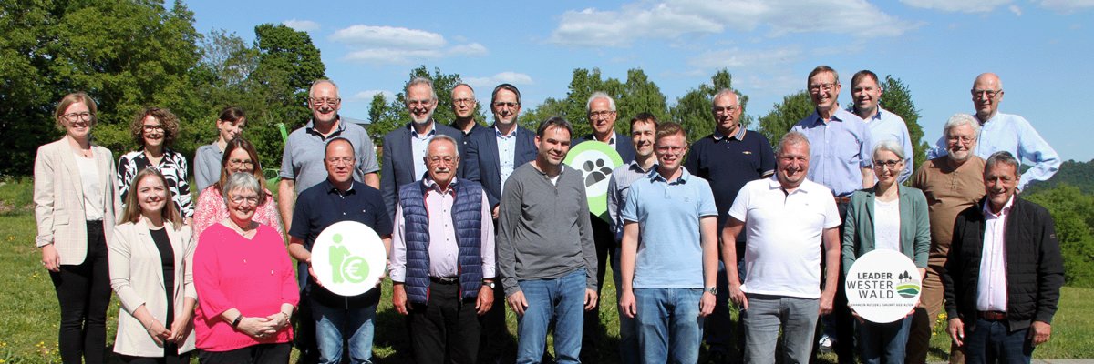 Eine Gruppe von Meschen steht in der Sonne.